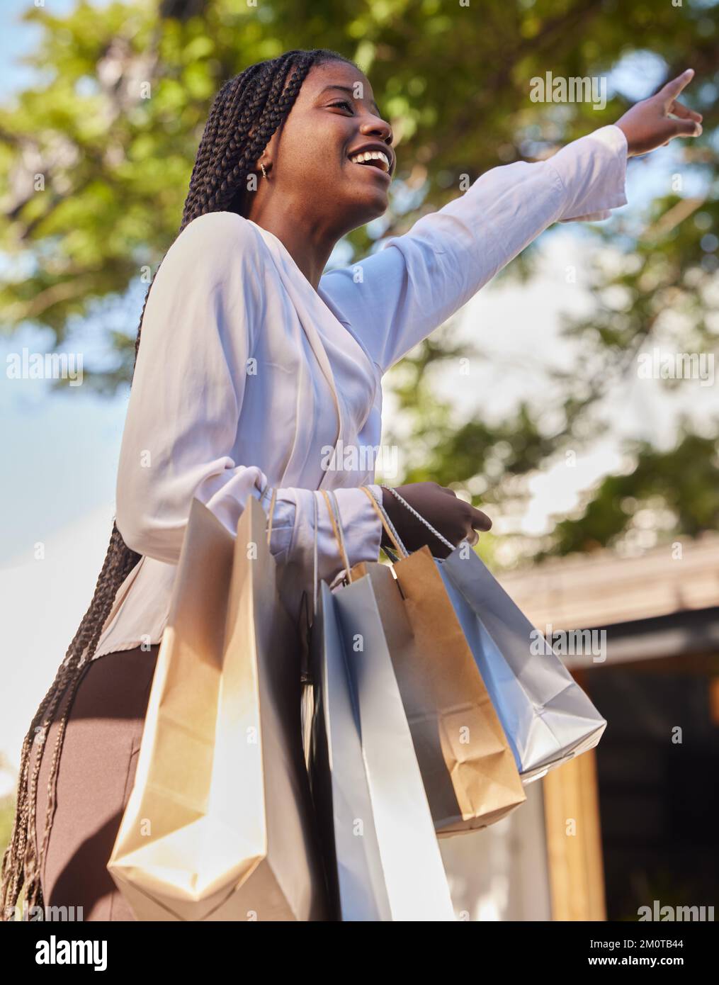 Schwarze Frau, Einkaufstüten und draußen auf der Straße, während sie glücklich war und ein Taxi oder Taxi für die Verbraucherreise suchte. Afrikanische Frau mit Stockfoto