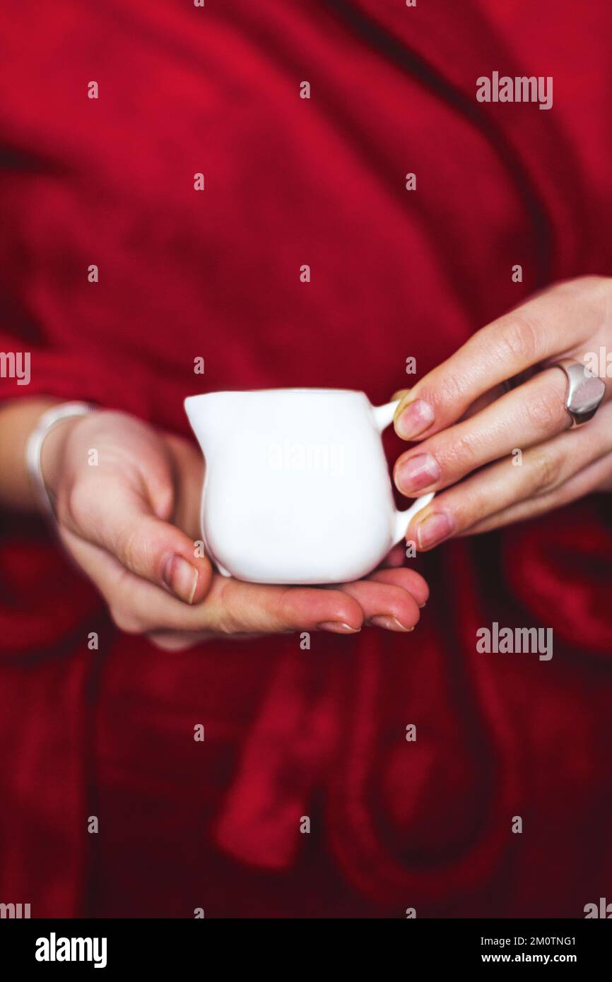 Eine Kerze in einem kleinen Krug in seinen Händen. Gemütliche Atmosphäre Stockfoto