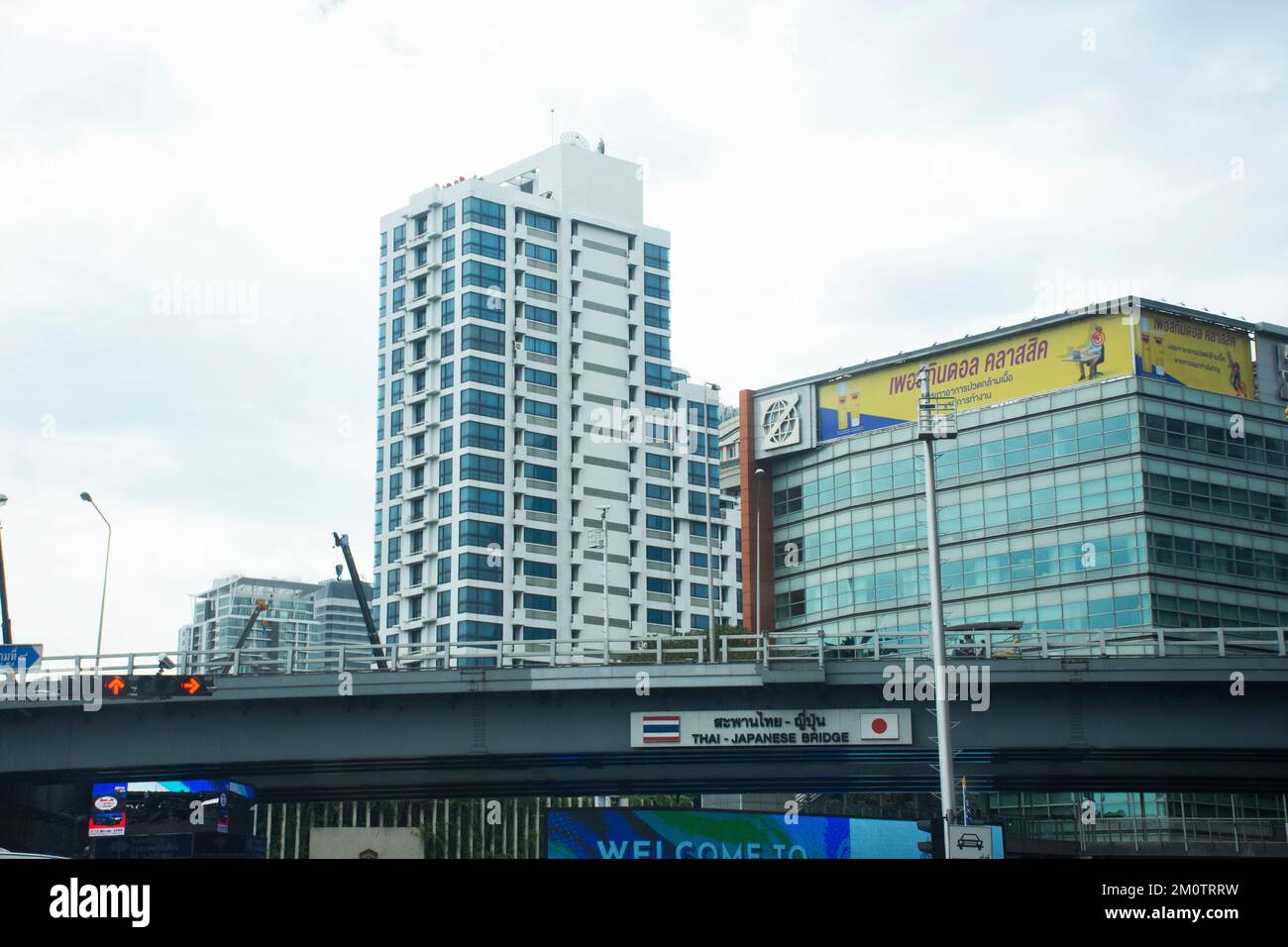 Werfen Sie einen Blick auf die thailändische und japanische Freundschaftsbrücke und das Büro im Hochhaus mit thailändischen Fahrern auf Straßen und Trappen Stockfoto