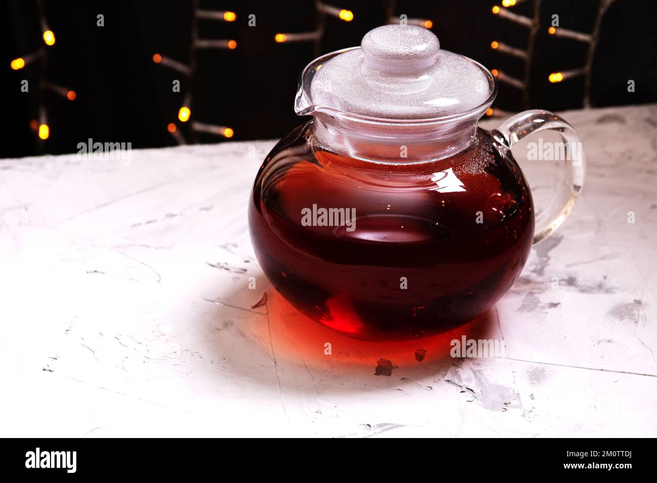 Wasserkocher aus Fotoglas mit Tee, der auf einem grauen Tisch steht Stockfoto