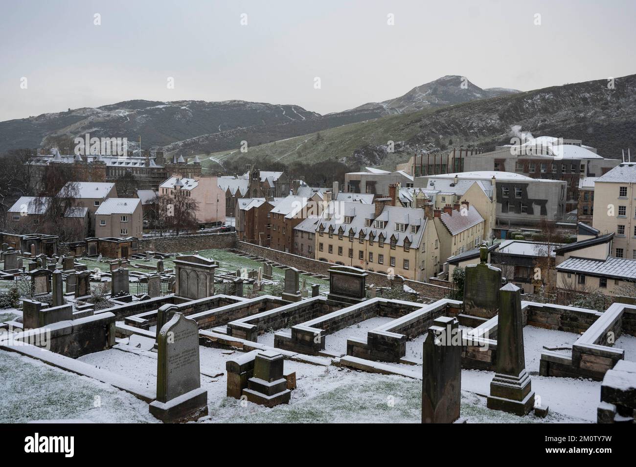 Donnerstag, 8.. Dezember 2022: Edinburgh, Schottland, Vereinigtes Königreich. Wetter. Ein kalter Witterungseinbruch im Vereinigten Königreich brachte eine leichte Schneebedeckung in die schottische Hauptstadt. Neues Grabstätte in Calton mit dem Palast von Holyroodhouse auf der linken Seite, Arthurs Seat und Salisbury Crags in der Ferne und Dampf aus dem schottischen Parlament. Stockfoto