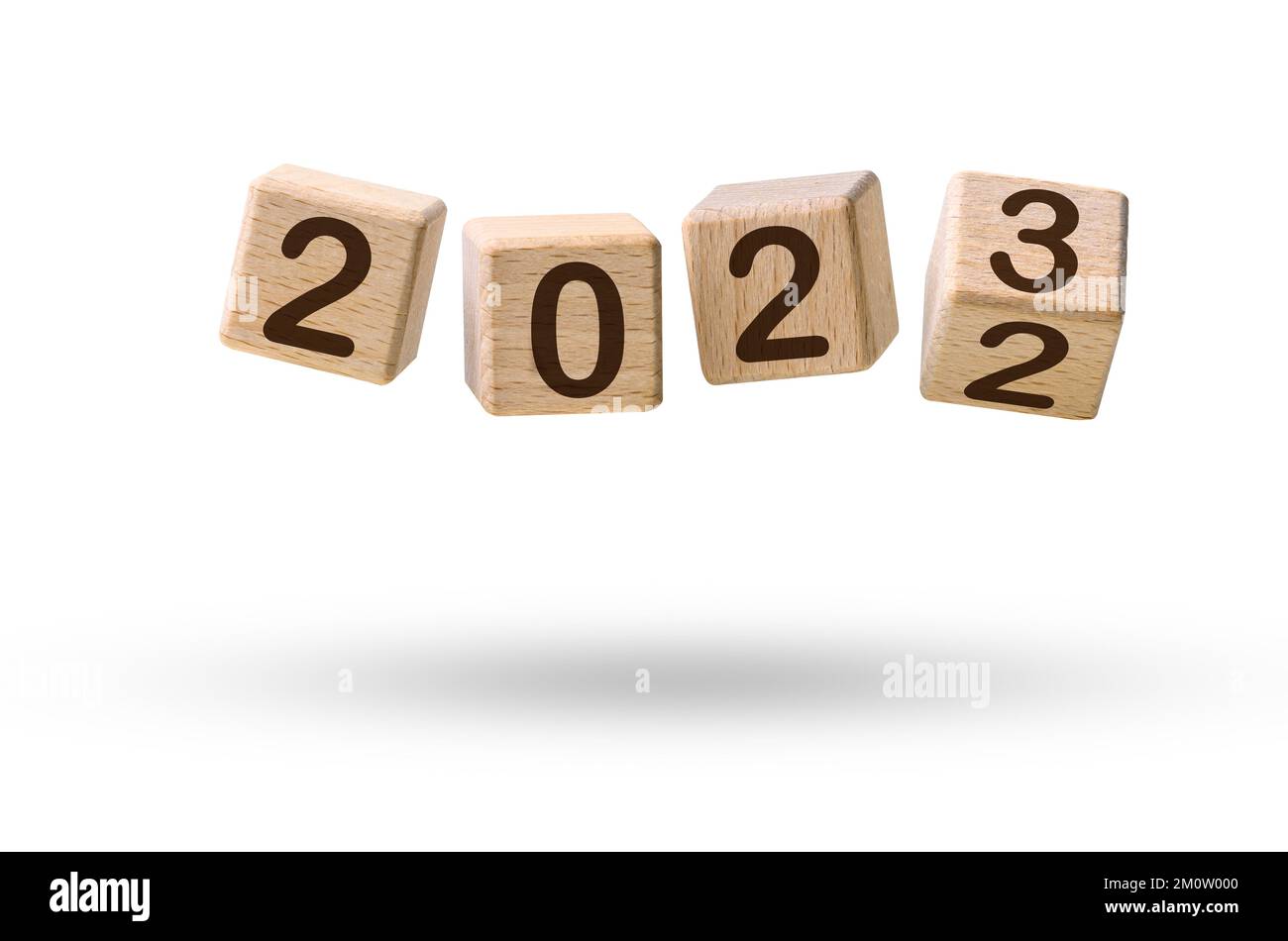 Frohes neues Jahreskonzept. Hölzerne Würfelblöcke, die von Neujahr 2022 auf 2023 umgestellt werden und über Weiß fliegen Stockfoto