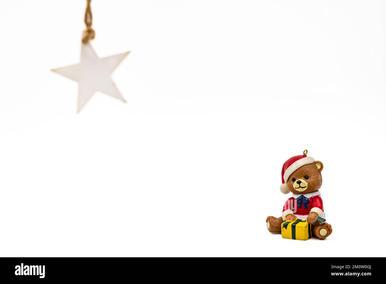 Farbenfroher Teddy mit Weihnachtsdekorationen auf weißem Hintergrund, zugeschnitten als Studioaufnahme für eine individuelle Fotogrußkarte Stockfoto