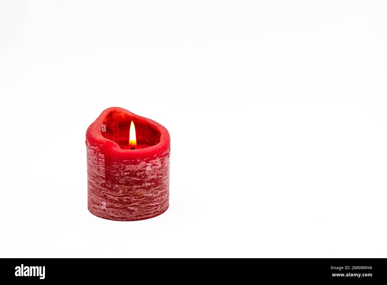 Grußkarte auf weißem Hintergrund mit brennender roter Kerze für Weihnachten und Adent als Studioaufnahme Stockfoto
