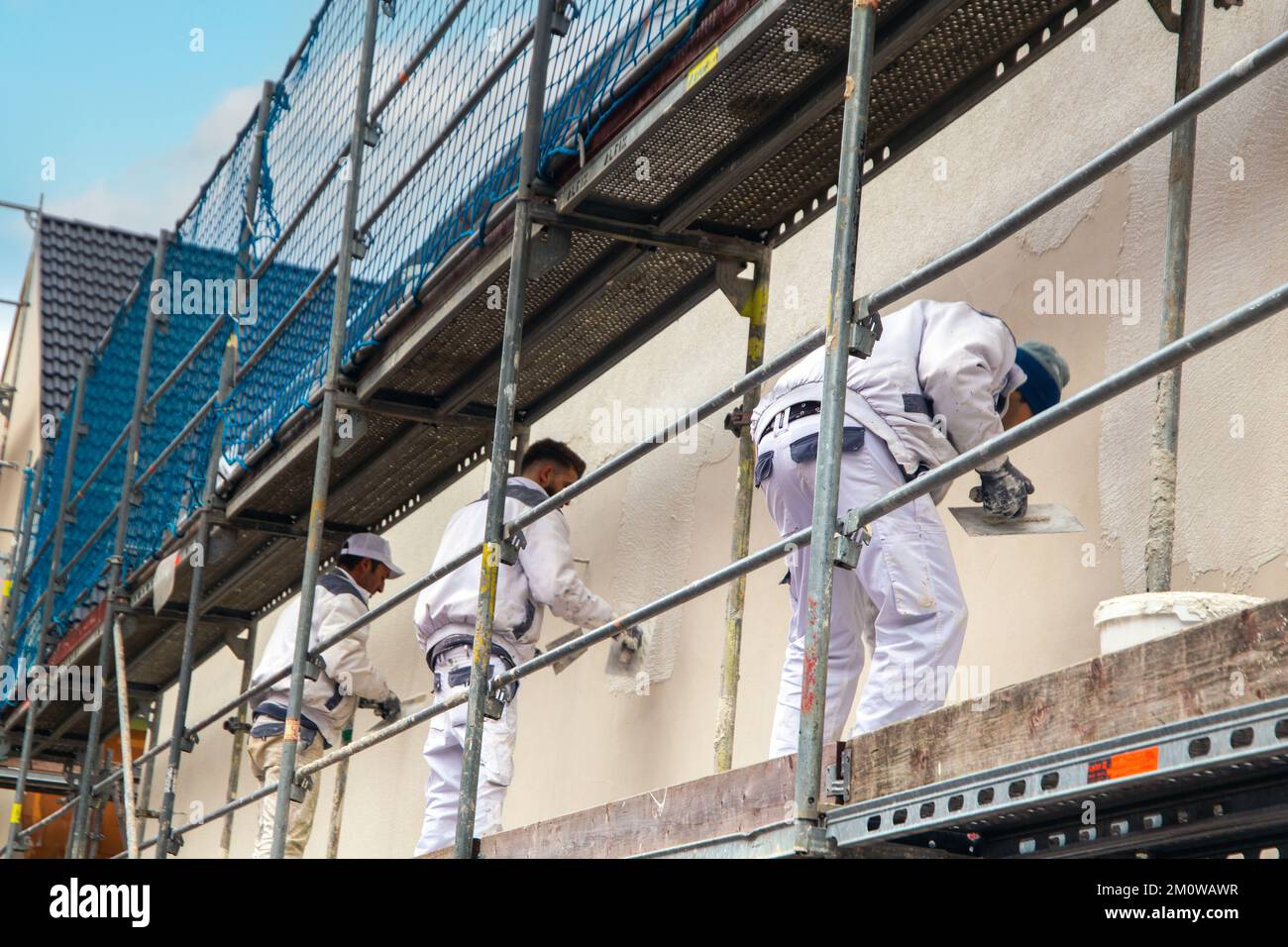 Maler, die die Außenfassade eines Wohnhauses in der Schulstraße in Mutterstadt besputzen Stockfoto