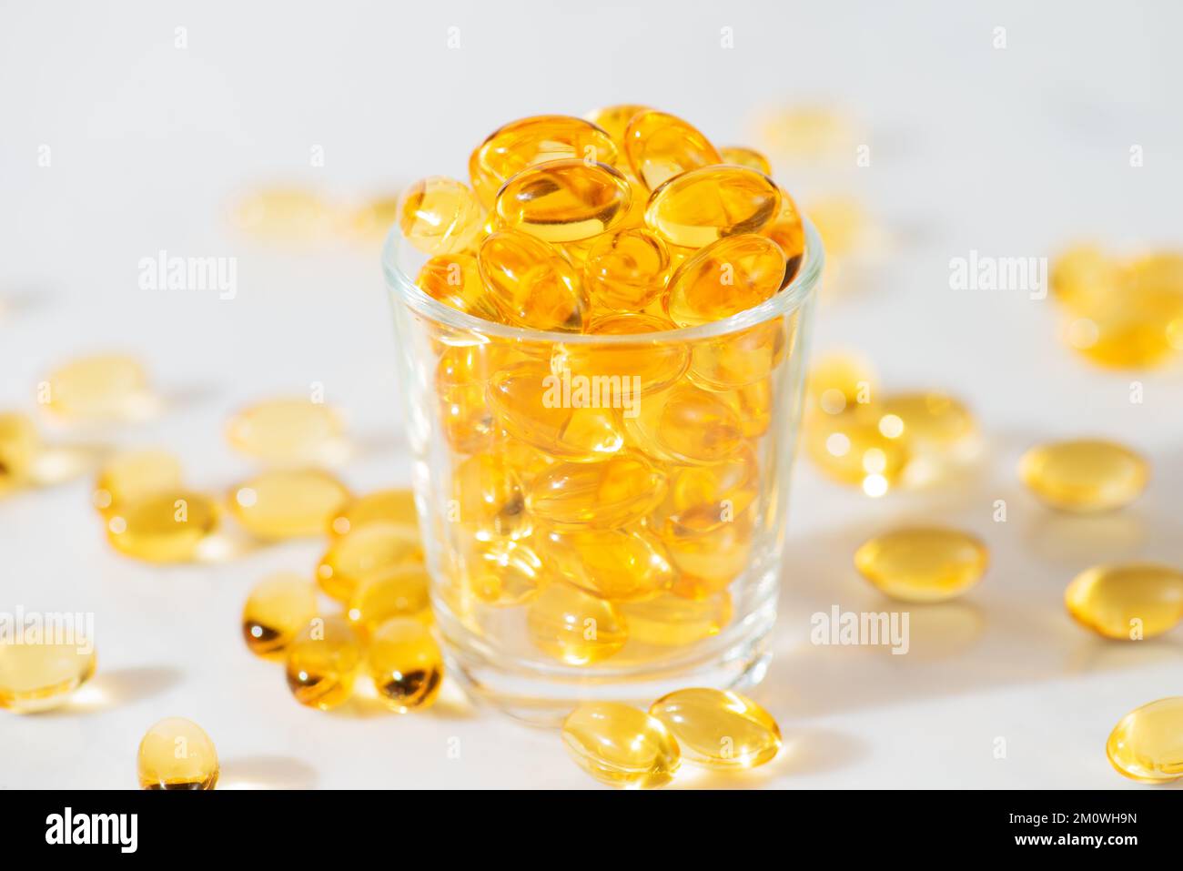 Fischöl Omega 3 Pillen Kapseln in einer Glasflasche auf weißem Marmorhintergrund, gesunde Ernährung, Nahrungsergänzungsmittel, Vitamine D. Stockfoto