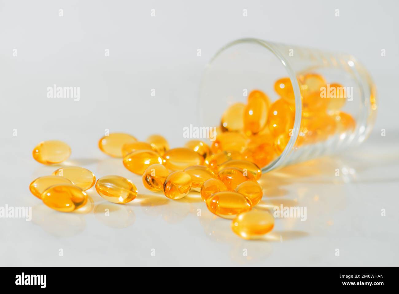 Fischöl Omega 3 Pillen Kapseln in einer Glasflasche auf weißem Marmorhintergrund, gesunde Ernährung, Nahrungsergänzungsmittel, Vitamine D. Stockfoto