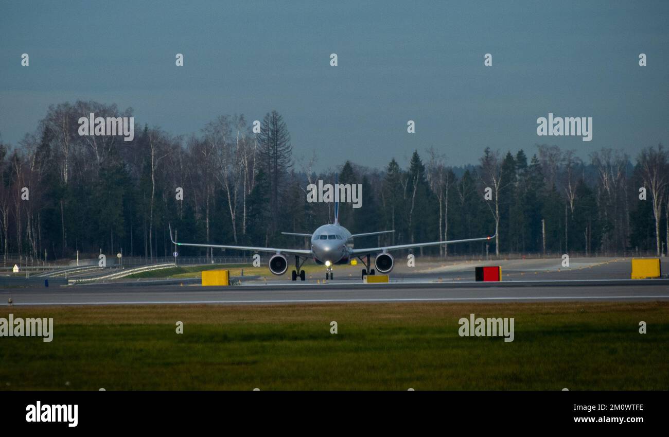 Ein modernes Passagierflugzeug in weißer Lackierung am internationalen Flughafen an einem bewölkten Morgen. Stockfoto