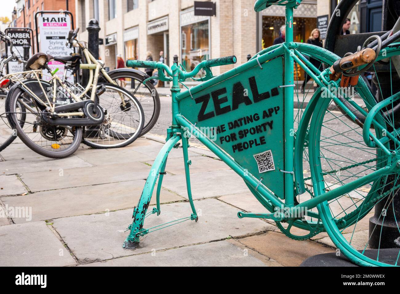 Die Dating-App für sportliche Leute. Werbung auf einem Fahrrad, das mit anderen Fahrrädern in Bishopsgate, London, Großbritannien, angekettet ist Stockfoto