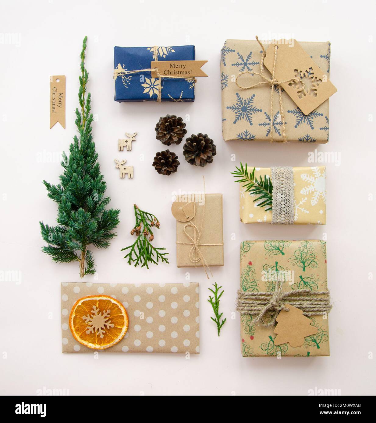 Umweltfreundliche Weihnachtsgestaltung mit Geschenkboxen aus wiederverwendbarem Papier und natürlicher Einrichtung auf weißem Hintergrund, Draufsicht. Keine Umweltverschwendung Stockfoto