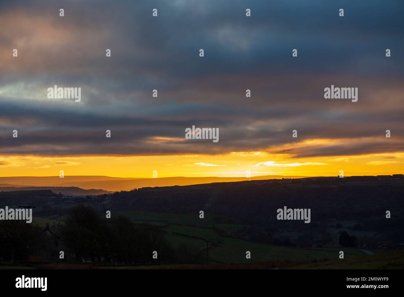 West Yorkshire, Großbritannien. 8.. Dezember 2022. Wetter in Großbritannien. Die Sonne geht über den Pennine Hills von Calderdale und dem Calder Valley unter, während die Temperaturen unter dem Gefrierpunkt sinken, wenn das Winterwetter Großbritannien erobert. Kredit: Windmill Images/Alamy Live News Stockfoto