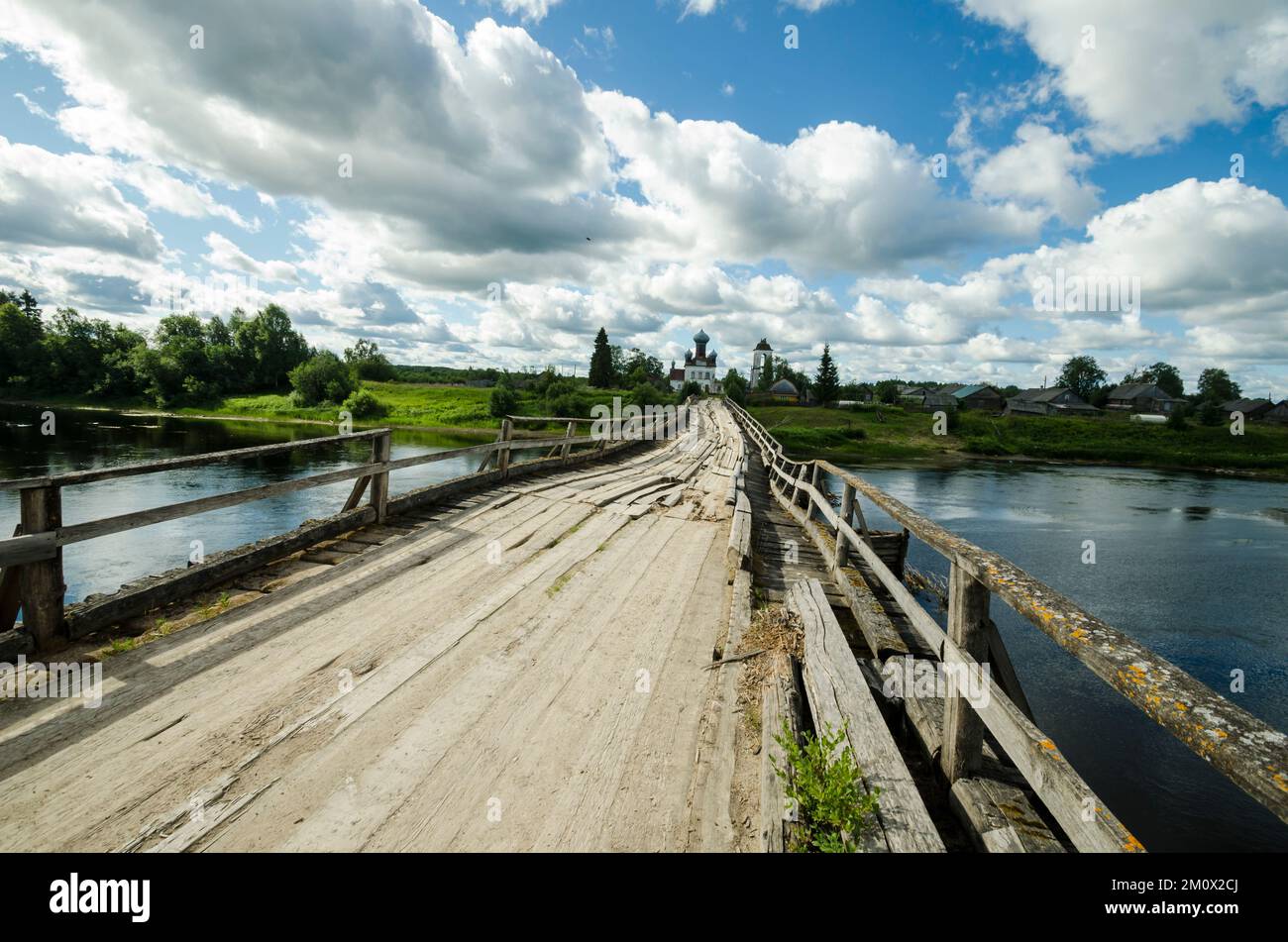 Verfallene schiefe Notbrücke über den Fluss. Weg zum Tempel Stockfoto