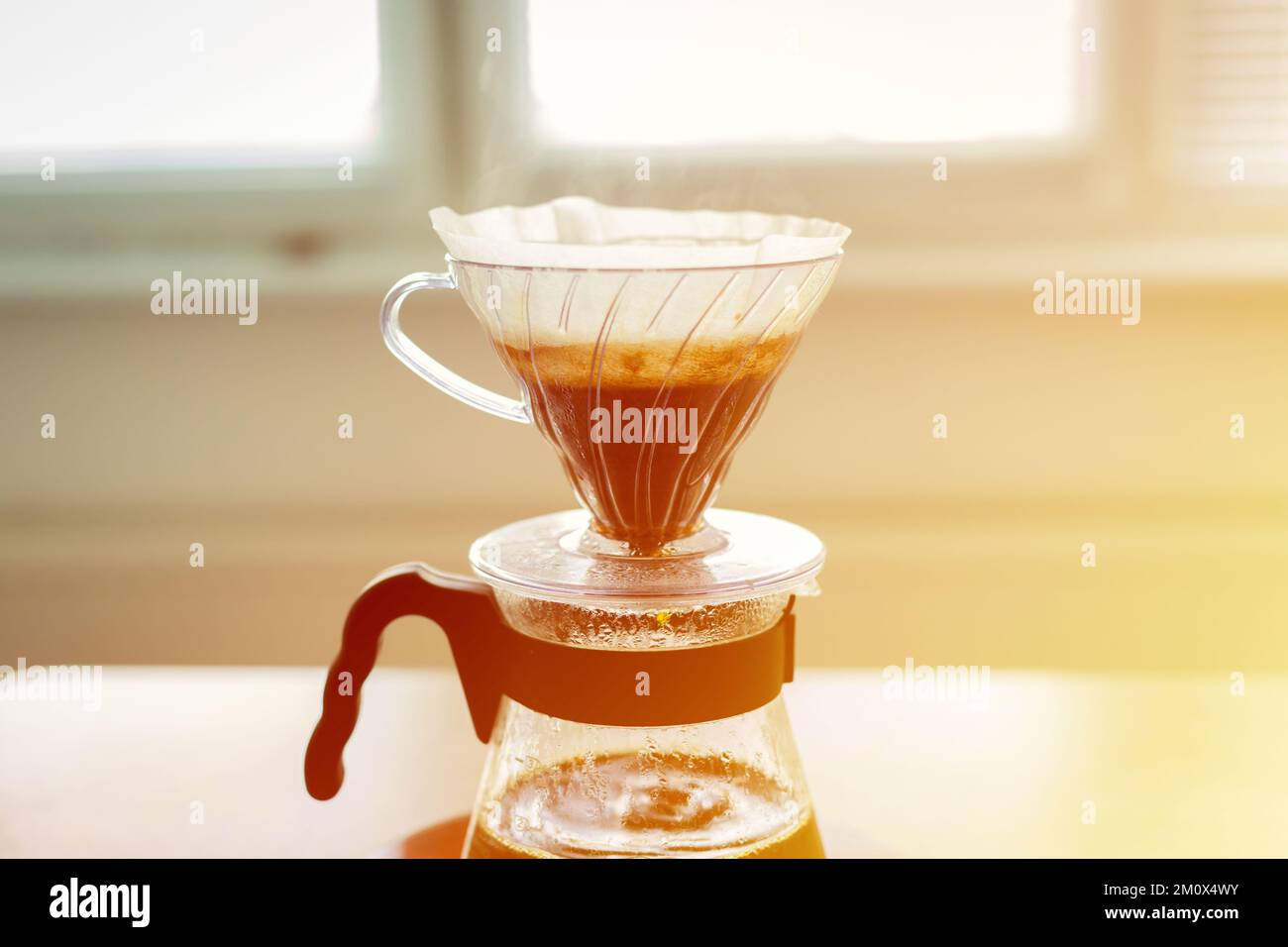 Nahaufnahme eines V60-dekanters, alternative Methode zum Brühen von Kaffee. Luftblasen auf dem Kaffeebett. Stockfoto