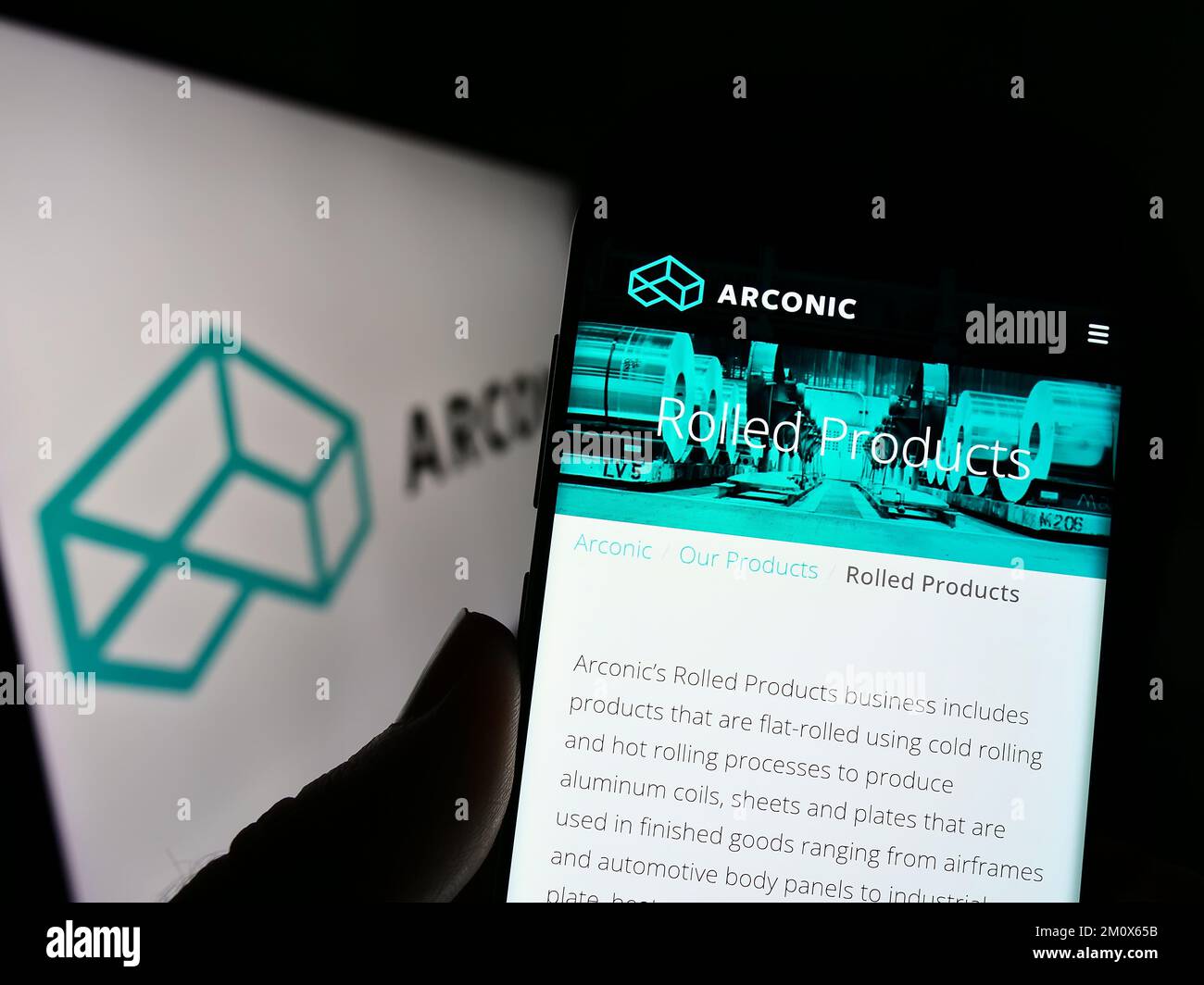 Person, die ein Mobiltelefon mit einer Webseite der US Metals Company Arconic Corporation auf dem Bildschirm vor dem Logo hält. Konzentrieren Sie sich auf die Mitte des Telefondisplays. Stockfoto