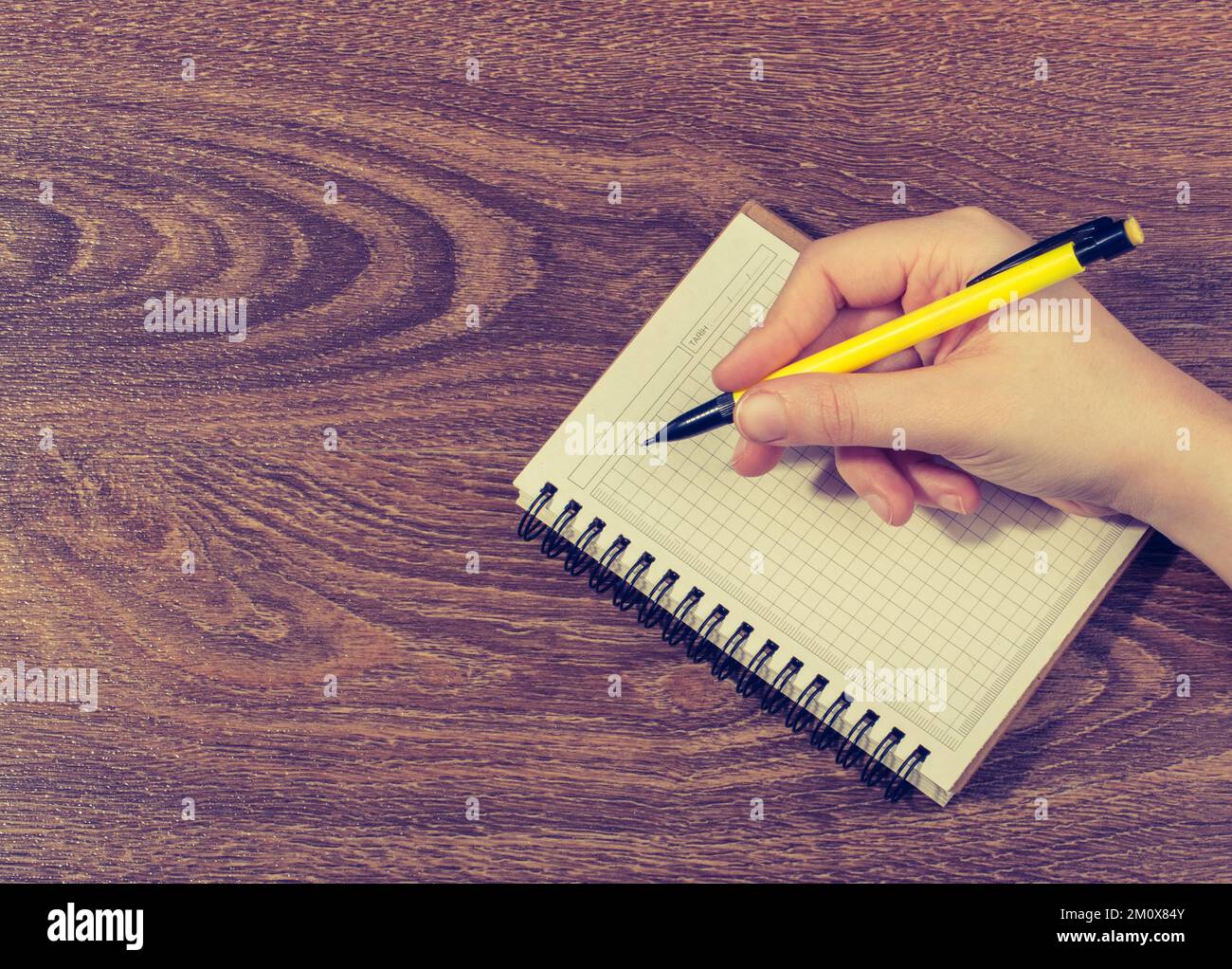 Handschrift in einem weißen Notizbuch auf braunem Hintergrund Stockfoto