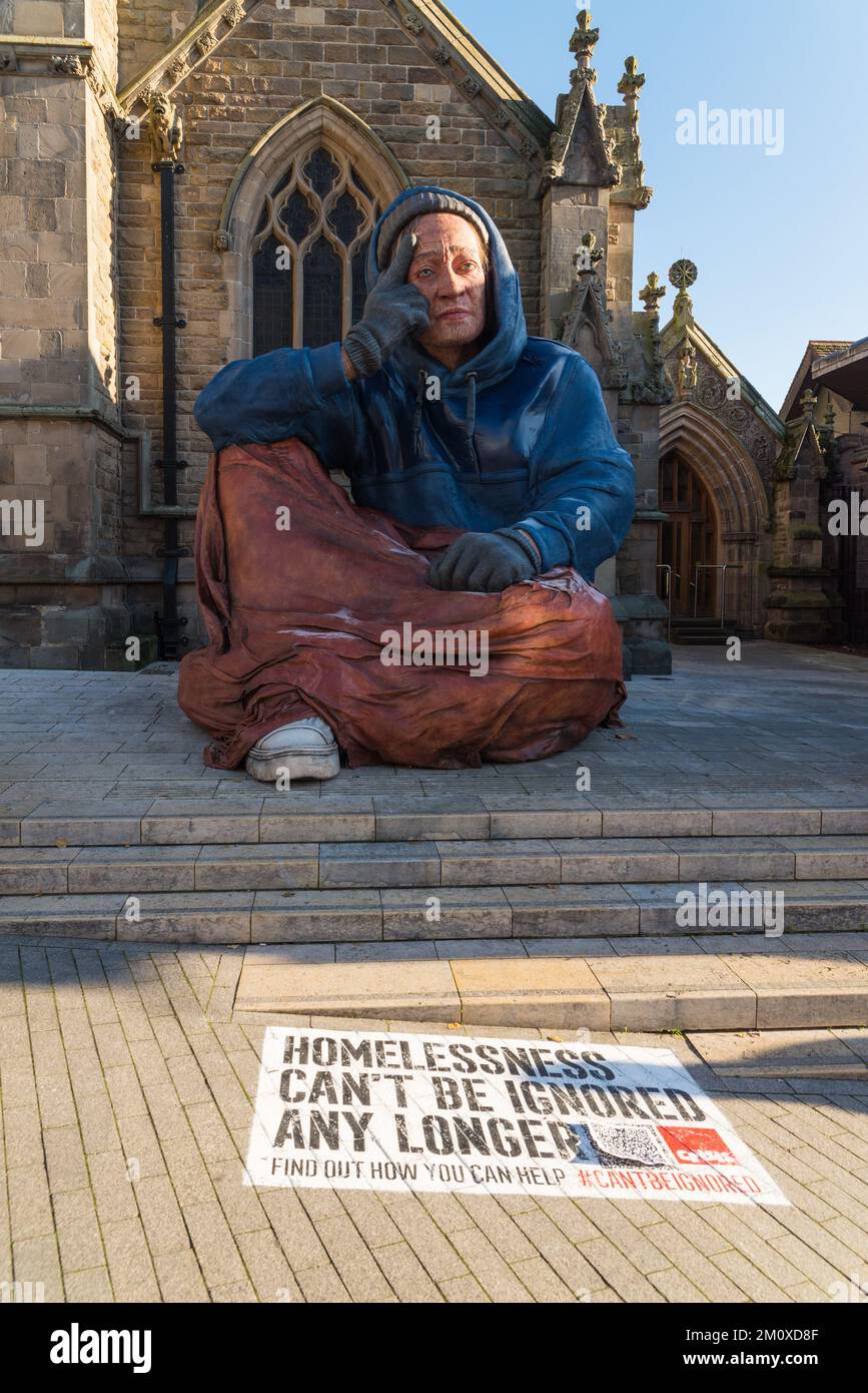 Große Obdachlosenstatue vor der St. Martin's Church im Stierkampf, Birmingham. Von Crisis UK installiert, um das Bewusstsein für Obdachlosigkeit zu fördern Stockfoto