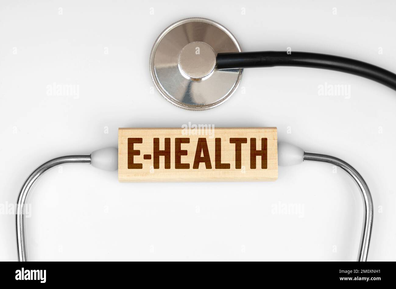 Gesundheits- und Medizinbegriff. Auf dem Tisch befinden sich ein Stethoskop und eine Holzplatte mit der Aufschrift E-Health Stockfoto