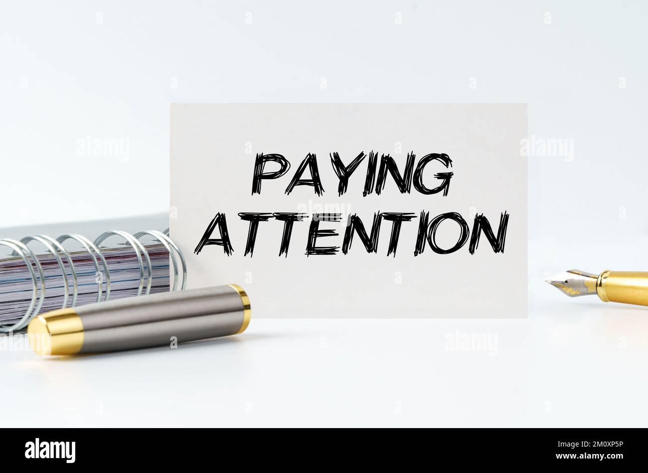 Geschäfts- und Finanzkonzept. Auf dem Tisch befinden sich ein Notizbuch, ein Stift und eine Visitenkarte mit der Aufschrift – ACHTUNG Stockfoto