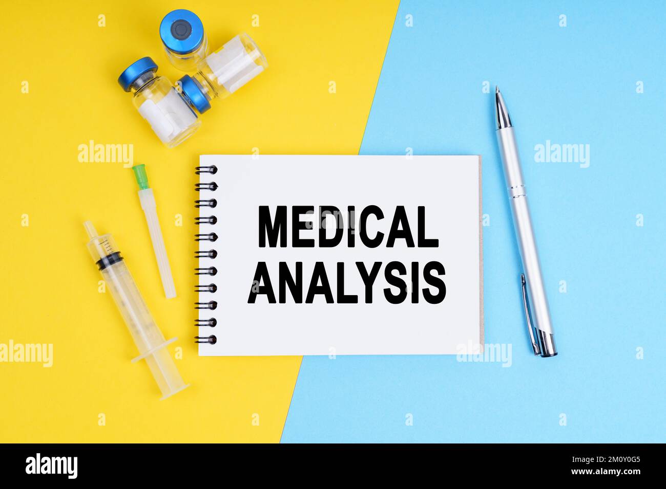 Medizin und Gesundheitskonzept. Eine Spritze, Ampullen und ein Notizbuch mit der Aufschrift - MEDIZINISCHE ANALYSE Stockfoto