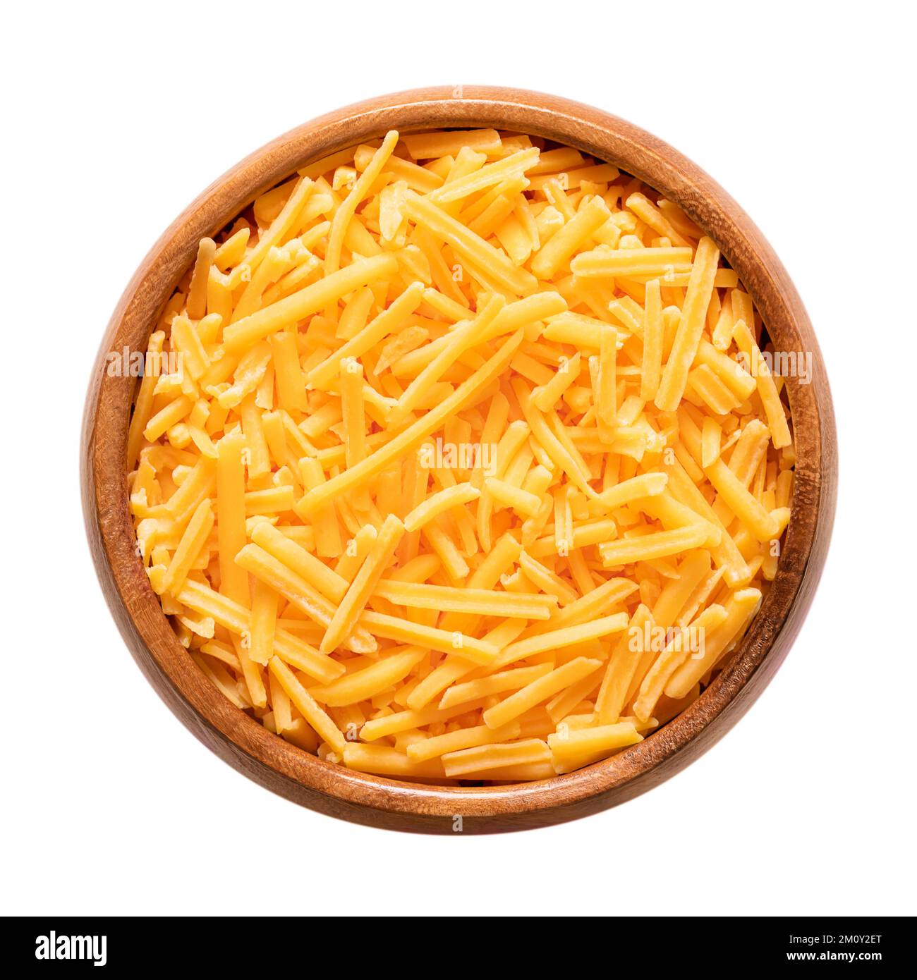 Zerkleinerter Cheddar-Käse in einer Holzschüssel. Geriebener Naturkäse, pikant, orange gefärbt mit Annatto, eine natürliche Lebensmittelfarbe. Stockfoto