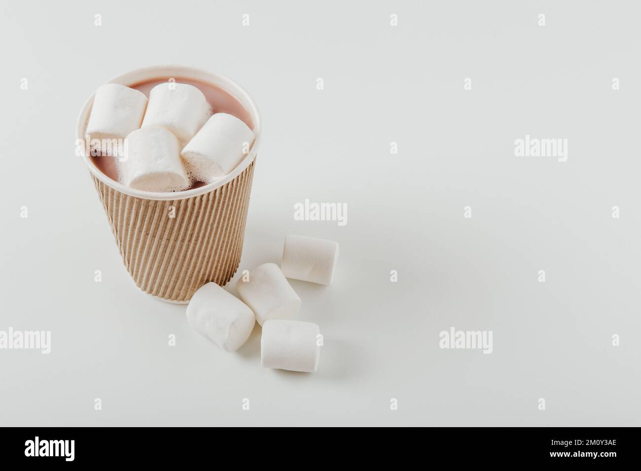 Pappbecher mit heißem Getränk und Marshmallows. Weißer Hintergrund. Kaffee, Latte, Cappuccino, Kakao. Einweg-Pappbecher. Recycling und umweltfreundliche Konz Stockfoto