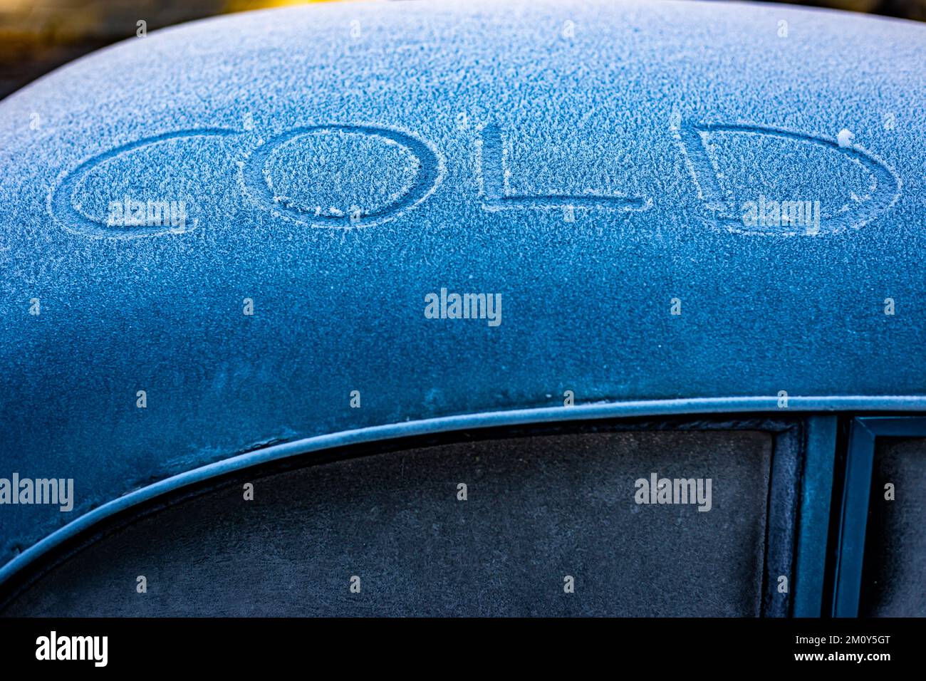 Kaltes Schild auf einem alten Austin-Auto. Eine Winterszene, in der die Temperaturen am Gefrierpunkt und bitterkalt sind. Die Farbe Blau sorgt für Drama Stockfoto