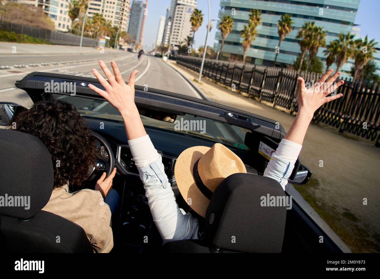 Fröhliches weißes Paar, das an einem sonnigen Tag im Cabrio fährt und die Freiheit in einer Stadt genießt Stockfoto