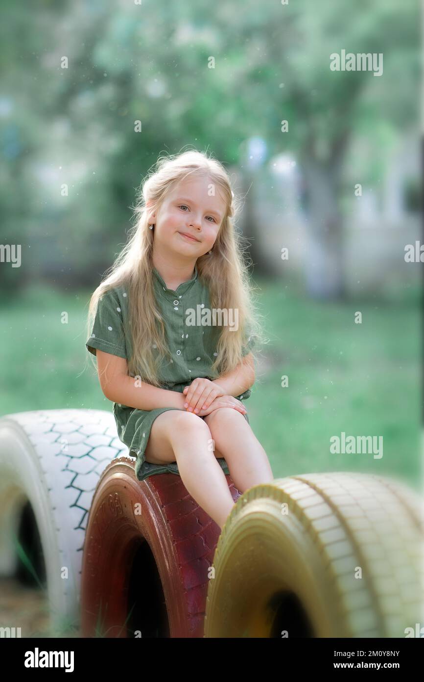 Ein Mädchen, das auf einer Bank sitzt und lächelt Stockfoto