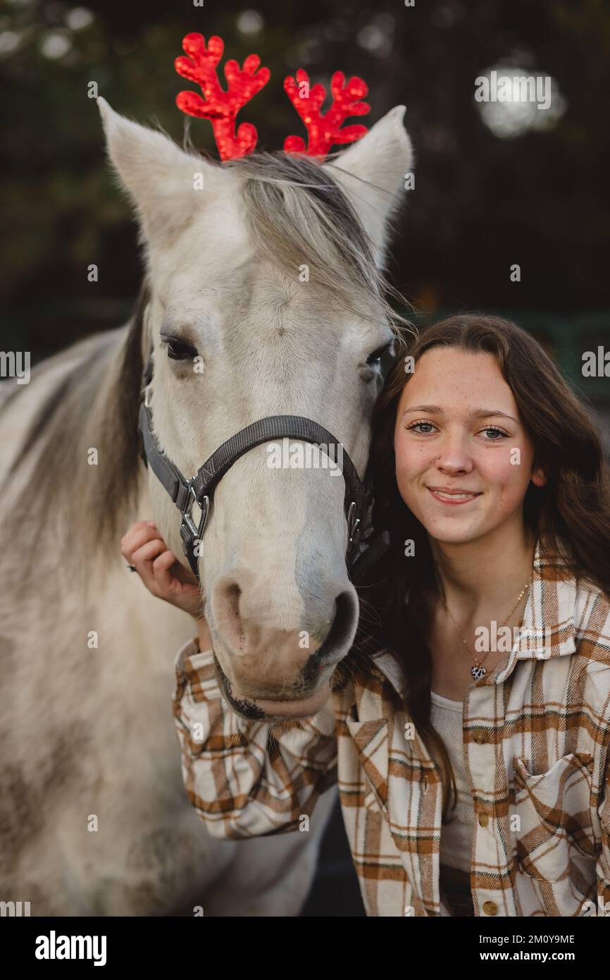 Rentierohren auf einem weißen Pferd mit Teenager-Mädchen Stockfoto
