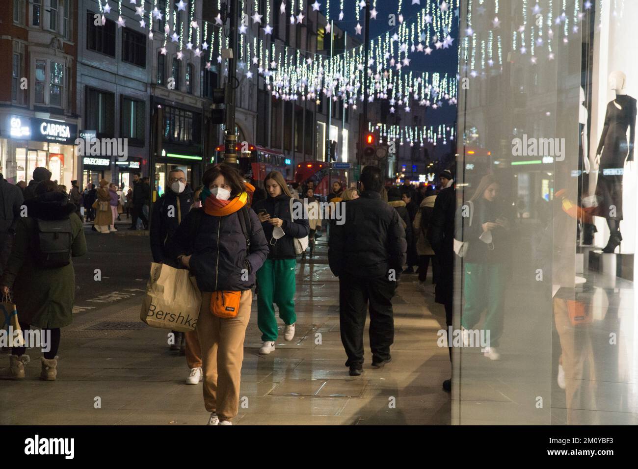 London, UK, 8. Dezember 2022: Weihnachtslichter sorgen bei Sonnenuntergang in der Oxford Street im West End für Glanz. Trotz der Bedenken hinsichtlich des Verbrauchervertrauens während der Krise der Lebenshaltungskosten drängen die Käufer auf die Straße. Anna Watson/Alamy Live News Stockfoto