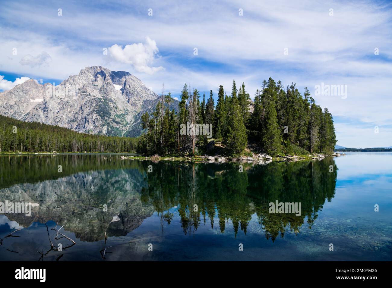 Berggipfel und von Bäumen bedeckte Insel im stillen Wasser des Leigh Lake im Grand Teton National Park, Wyoming Stockfoto