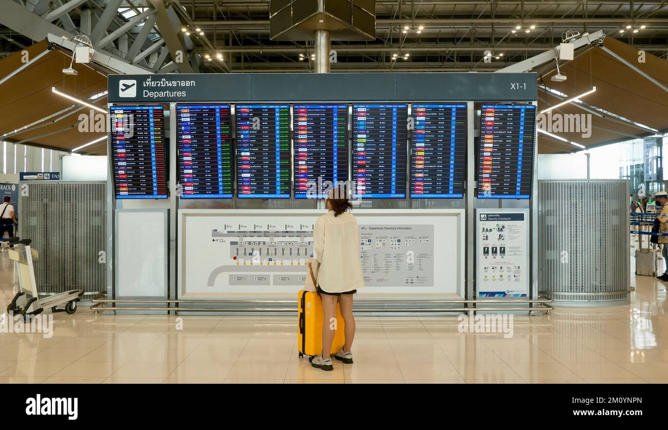 Bangkok, Thailand - 21. Juli 2022. Eine weibliche Passagierin sieht sich die Fluginformationen auf der Abflugsanzeige am Flughafen Suvarnabhumi (BKK) an. Stockfoto
