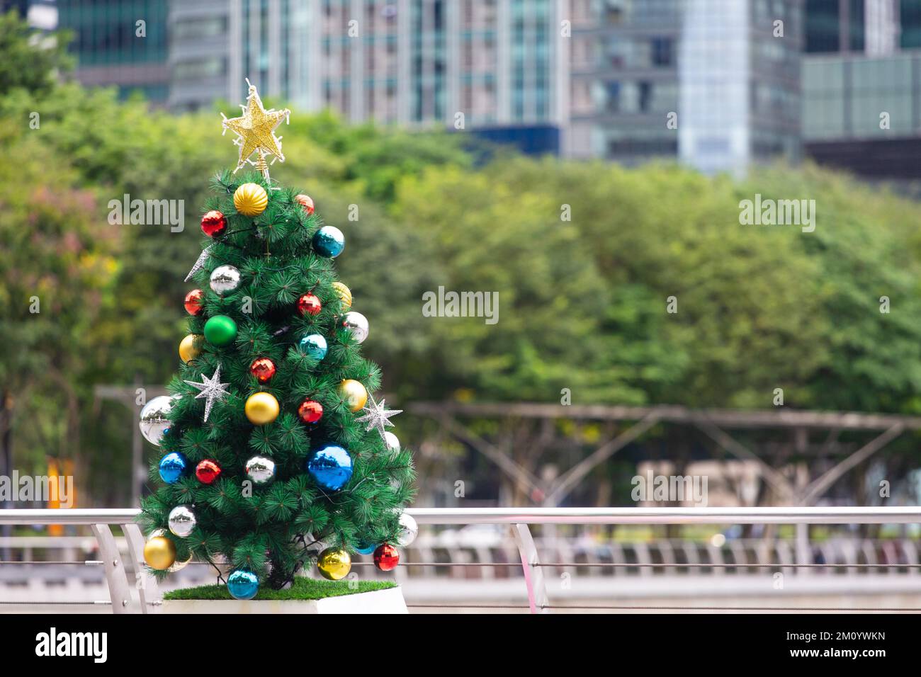 Beeindruckende Weihnachtsbaumdekoration im Außenbereich vor dem grünen und modernen Architekturgebäude. Stockfoto