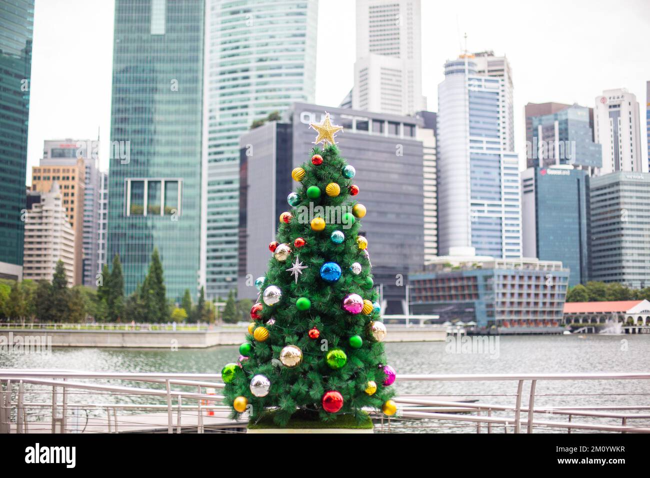 Weihnachtsbaumdekoration vor dem Hintergrund moderner Hochhäuser im zentralen Stadtbereich. Urlaubsstimmung im urbanen Raum. Singapur. Stockfoto