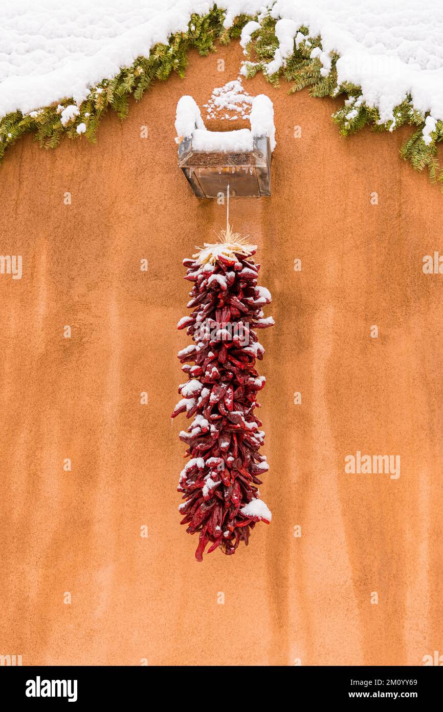 Winterweihnachtsszene einer schneebedeckten roten chilenischen Ristra in Santa Fe, New Mexico Stockfoto