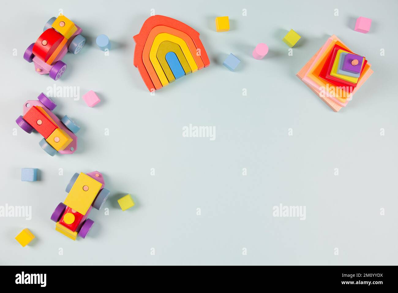 Hintergrund für Kinderspielzeug. Holzzug, farbenfrohe pädagogische Spielzeuge aus natürlichem Holz auf hellblauem Hintergrund. Montessori, umweltfreundliches Kinderspielzeug Stockfoto