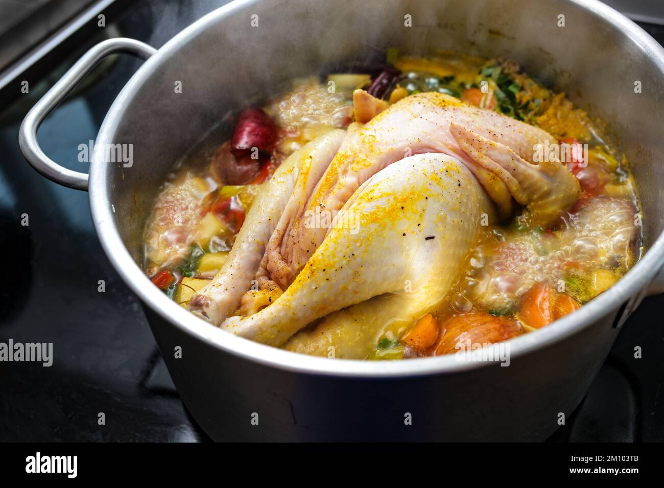Hühnersuppe mit Gemüse und Gewürzen kocht in einem Topf, kocht eine ...