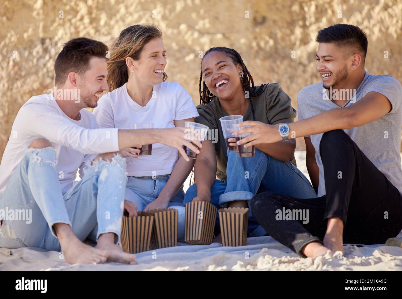 Picknick am Strand, Freunde und Toast in der Natur auf Urlaub, Urlaub oder Sommerurlaub. Gruppenjubel, Lächeln und glückliche Frauen, die sich mit Alkohol, Alkohol oder verbinden Stockfoto