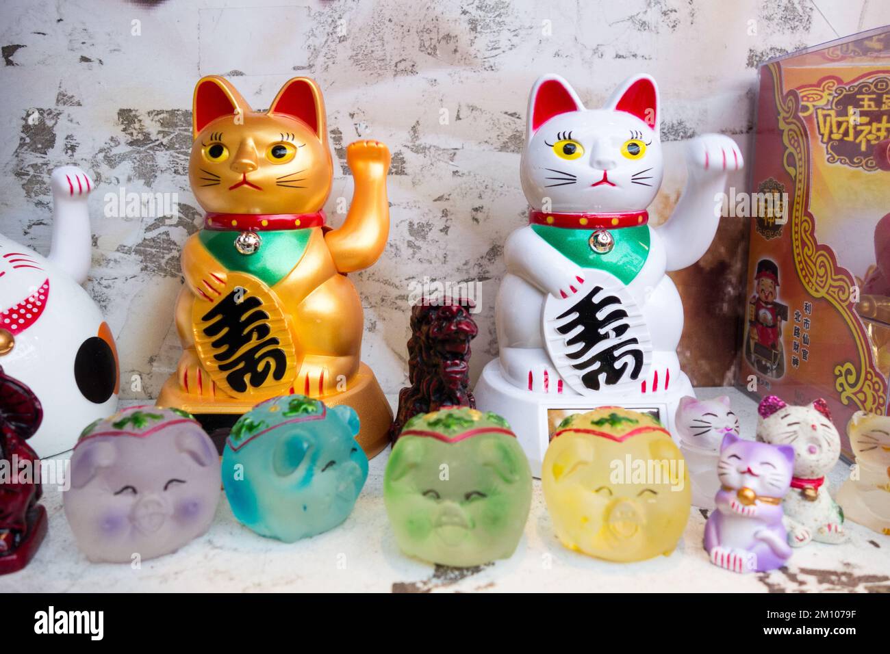 Nahaufnahme von Maneki Neko (japanische Weckkatzen) in einem Restaurantfenster in China Town, Soho, London, England, Großbritannien Stockfoto