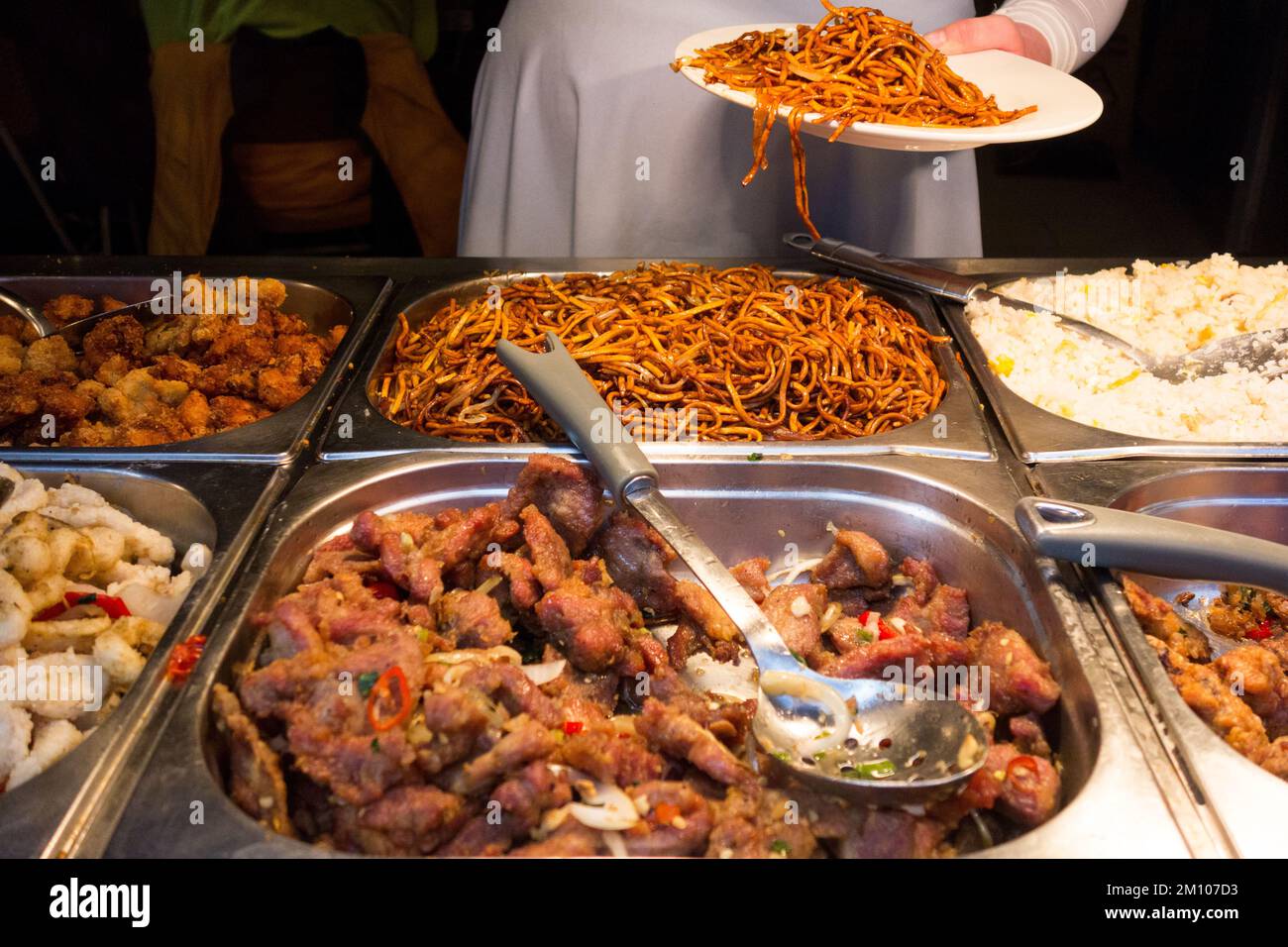 Eine schwangere Kundin mit einem Teller voller Nudeln in einem chinesischen Selbstbedienungsrestaurant in China Town, Soho, London, England, Großbritannien. Stockfoto