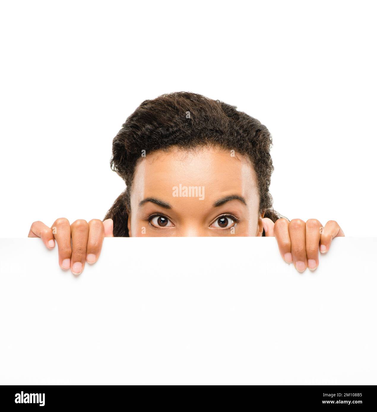 Sich vor ihrem eigenen Erfolg zu verstecken. Eine junge Geschäftsfrau, die hinter einem Plakat vor einem Studiohintergrund aufblickt. Stockfoto