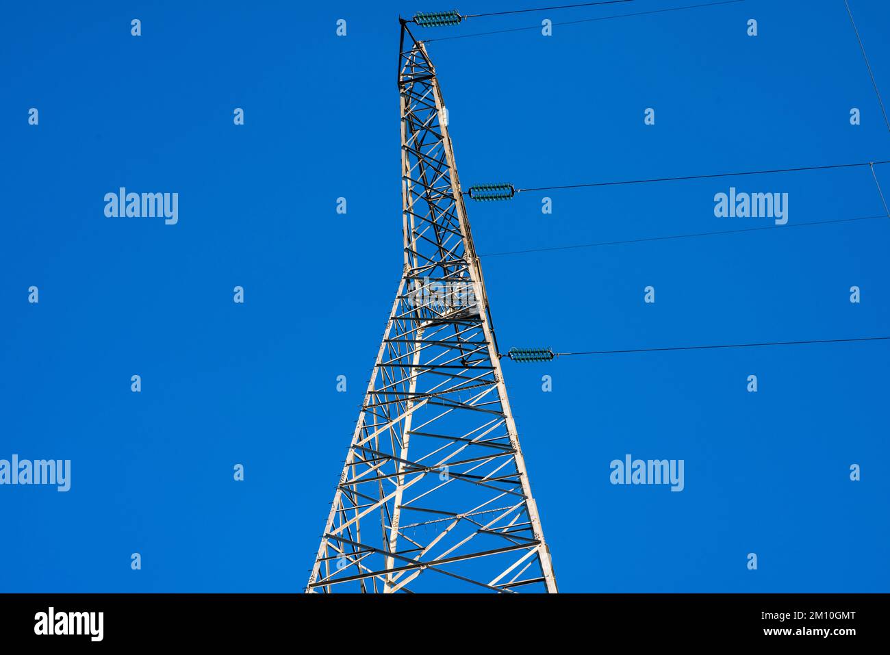 Hochspannungs-Strompylon mit elektrischen Kabeln vom Anfangspunkt der Anlage bis zum Boden. Die kostspielige Energie in dieser Zeit liegt im Stockfoto