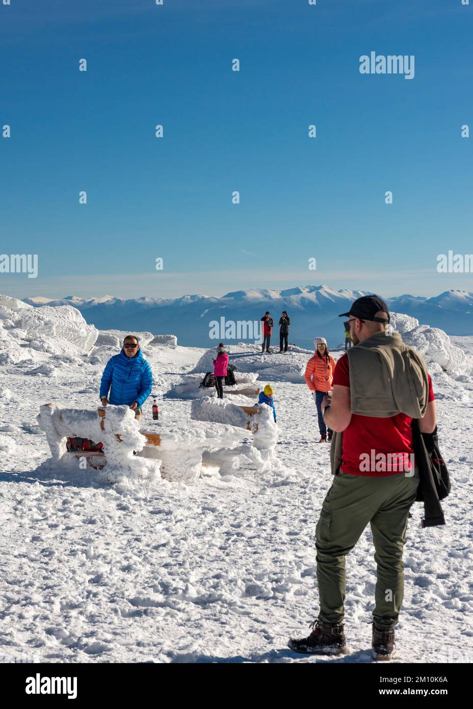 Menschen, die den Schnee auf dem Black Peak Summit um 2290m Uhr im Vitosha Mountain mit Blick auf die Rila Mountains, Bulgarien, Osteuropa, Balkan, EU genießen Stockfoto