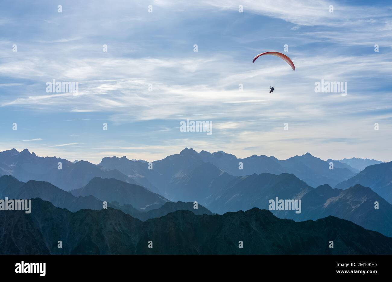 Gleitschirmfliegen über den blauen Bergen Silhouette, Allgaeu, Oberstdorf, Alpen, Deutschland. Reiseziel. Freiheit- und Urlaubskonzept. Stockfoto