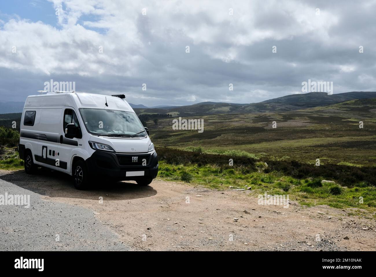 Vorderansicht des Wohnwagens, der an der Straße geparkt ist und die Landschaft in Cairngorms überblickt Stockfoto