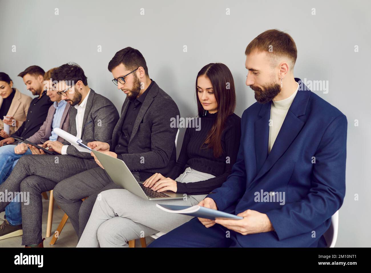 Gruppe von Geschäftsleuten, die im Büro sitzen, an ihren Projekten arbeiten und Laptops verwenden Stockfoto