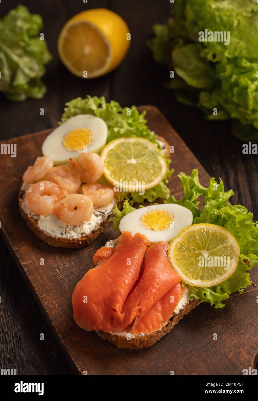 Die Toasts mit gekochten Eiern, Salat, Zitronenschleim, Garnelen und ...