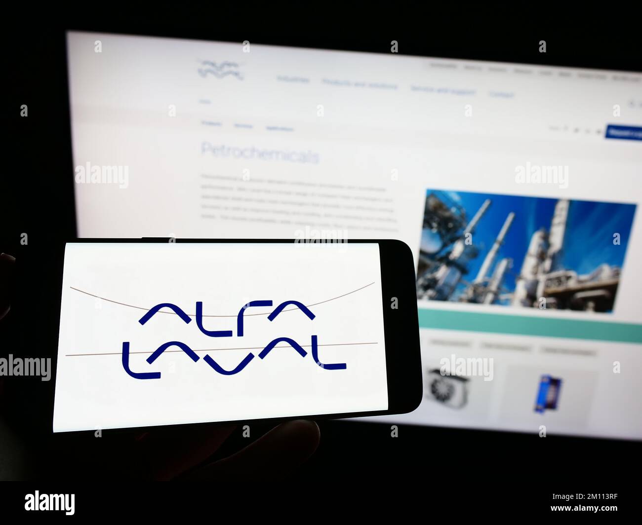 Person, die ein Smartphone mit dem Logo des schwedischen Unternehmens Alfa Laval ab auf dem Bildschirm vor der Website hält. Konzentrieren Sie sich auf das Display des Telefons. Stockfoto