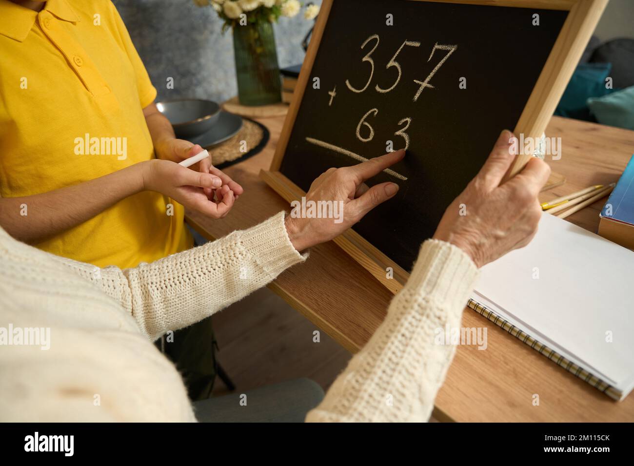 Lady hilft Enkelsohn, zu Hause Mathematik zu lernen Stockfoto