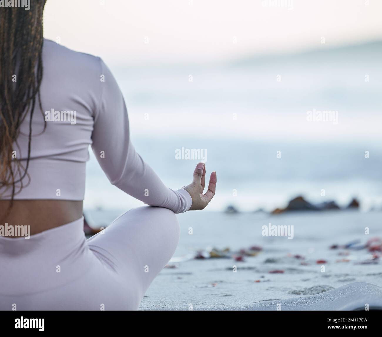 Strand, Yoga und Lotus mit schwarzer Frau in Meditation für Ruhe, Frieden und Zen mit Fitness, Training und Workout-Modell. Meer, Wellen und Frau Stockfoto